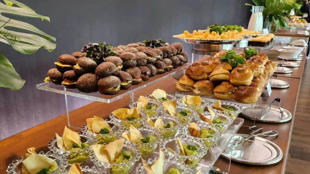 Buffet corporativo com mini sanduíches e entradas