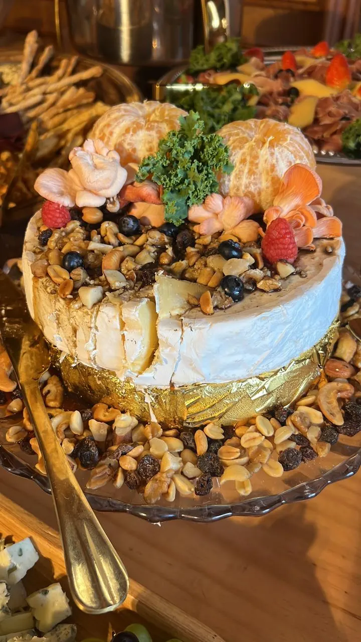 Queijo brie decorado com castanhas, frutas e flores